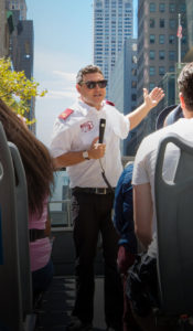 Big Bus tour guide with microphone on top of a bus